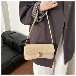 Detail view of a beige leopard print shoulder bag with a gold metal clasp lock