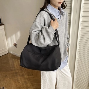 Vintage black large capacity pillow bag worn as a shoulder bag in minimalist style