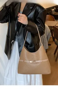 Detailed texture of brown crocodile pattern shoulder bag with a gold metal buckle