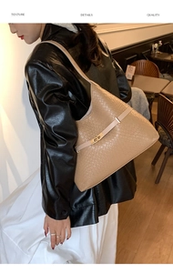 Detail showing high-quality camel woven leather texture and elegant gold metal buckle lock