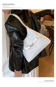 Close-up of white woven hobo bag with gold metal buckle and light practical design