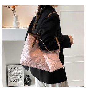 Pink woven tote bag with matching pouch and brown straps on professional model