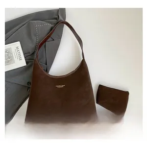 Détail de l'ensemble cabas marron foncé en daim avec logo doré et pochette assortie