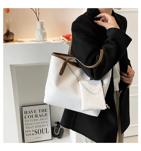 Detailed woven texture of white tote bag with brown leather handles and small pouch