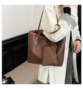 Detail of dark brown woven tote bag with matching zipper pouch and contrast strap