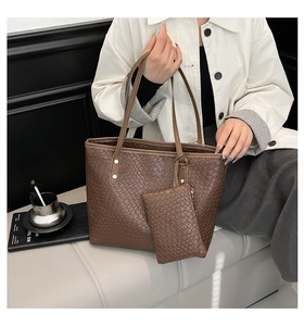 Detail of dark brown woven tote bag with matching mini pouch and metallic rivets