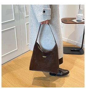 Detail of matte dark coffee tote bag with gold lettering and wide shoulder strap