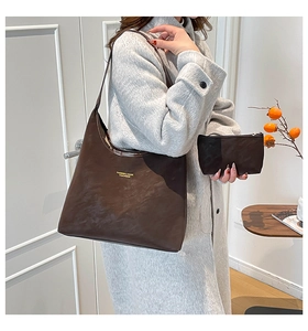 Detail of dark brown matte tote bag and matching pouch shown with grey wool coat