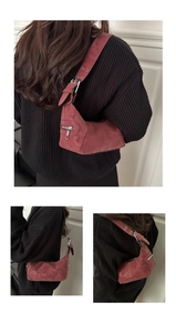 Detail of burgundy moon bag with silver zipper and eyelet adjustable strap
