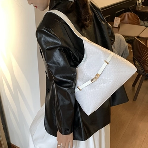 Minimalist white woven leather hobo bag with gold buckle on shoulder strap shown on model