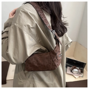 Photo portée d'un sac cabas marron à motif léopard avec des détails métalliques