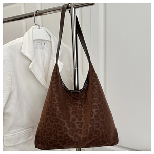 Gros plan du sac cabas vintage à motif léopard sur un fond en velours côtelé blanc