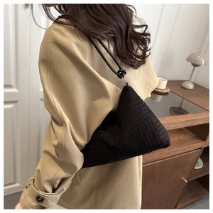 Détail du sac bandoulière noir en velours côtelé avec texture géométrique et maille jacquard