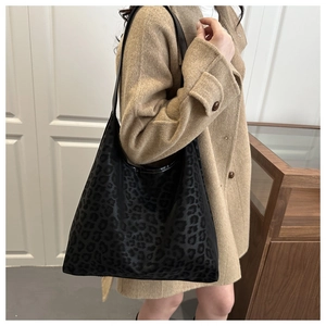 Detail of vintage leopard print tote bag with soft texture and long shoulder strap