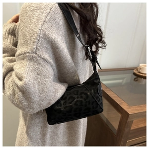 Détail d'un sac sous les bras chic à motif léopard avec bandoulière cuir et zip argenté