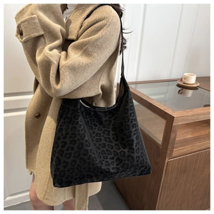 Detail shot of leopard print hobo tote bag texture and spacious capacity on model