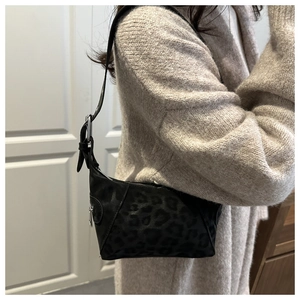 Close-up of stylish leopard print shoulder bag with adjustable strap and silver zipper