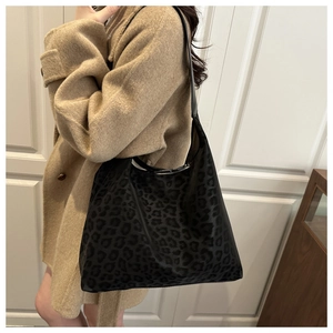 Detail of soft leopard print tote bag texture and long shoulder strap in autumn style