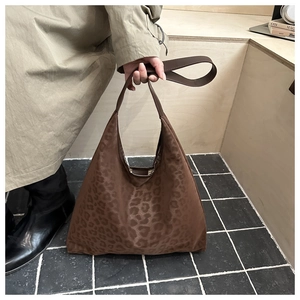 Détail d'un grand sac hobo léopard avec large bandoulière sur un mannequin