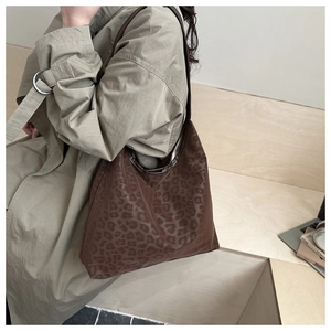 Detail of vintage leopard print hobo bag with glossy texture and slim shoulder strap