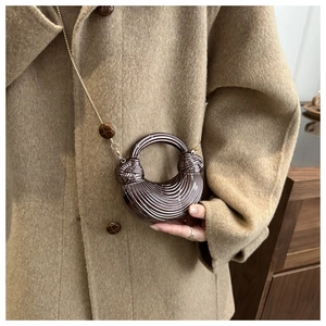 Dettaglio mini borsa caffè con trama a coste e manico a treccia su cappotto color cammello