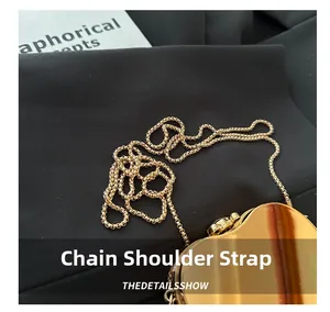 Close-up of premium gold metal chain strap on a heart-shaped evening clutch bag