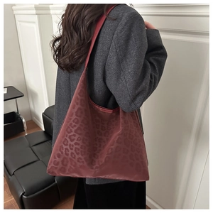 Detail view of large burgundy tote bag with leopard print on glossy waterproof fabric