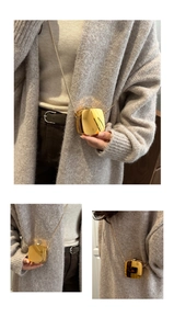Detail of a shiny gold metal mini box bag with elegant round snake chain on a model