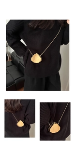 Detailed view of a mini hexagonal gold metal crossbody bag with fine chain strap and mirror finish