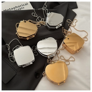 Detail of mirror-finish mini chain bags in gold and silver, heart and geometric shapes
