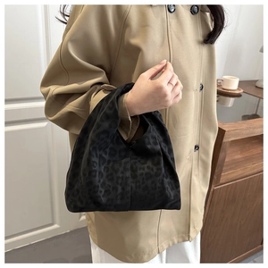 Detail of black leopard print handbag in jacquard fabric with elegant soft lighting