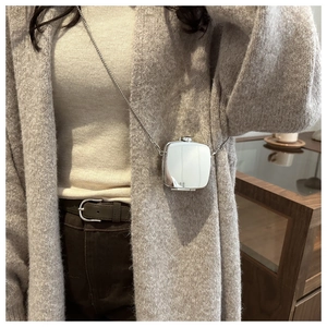 Mini silver mirror metal crossbody bag with fine chain shown on model in grey knit