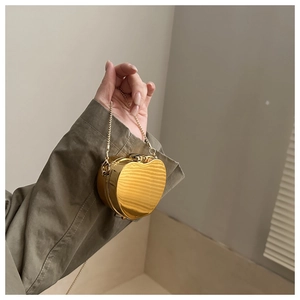 Vue détaillée du mini sac cœur doré rigide avec texture ondulée et fine bandoulière