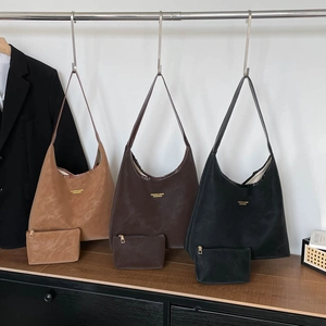 Drei minimalistische Hobo-Taschen aus mattem Leder mit passenden Beuteln in Braun und Schwarz