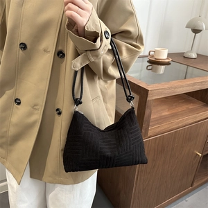 Sac fourre-tout rétro noir à damier avec bandoulière porté par un mannequin élégant