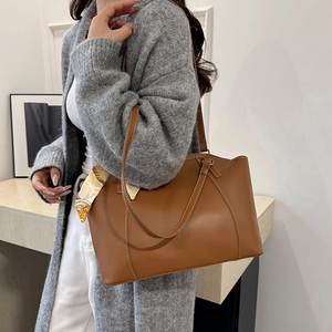 Brown soft leather tote bag with white contrast stitching and a decorative silk scarf