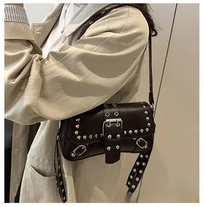 Dettaglio borsa a tracolla marrone scuro stile punk con borchie argentate e fibbia in pelle