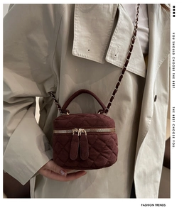 Detalle del mini bolso burdeos acolchado con cadena dorada y doble cremallera