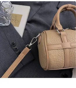 Detail of durable metal hooks and crocodile pattern texture on khaki Boston bag