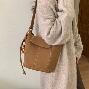 Minimalistische braune Leder-Beuteltasche mit Kontrastnähten und Quastenanhänger