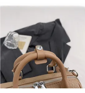 Detail of elegant crocodile pattern leather and silver zipper hardware on Boston bag