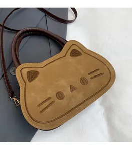 Détail du sac bandoulière chat en daim chameau avec broderie et poignées en cuir