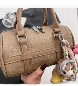 Close-up of khaki Boston bag featuring crocodile pattern leather and silver zipper detail