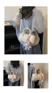 Detail view of white lychee pattern Boston bag with teddy bear charm and strap