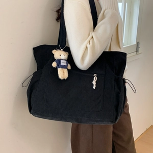 Black corduroy tote bag with bear charm shown on model for daily casual style