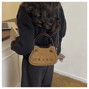 Modèle de dos portant un sac bandoulière marron en forme de chat avec broderies