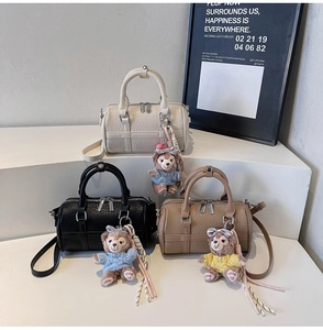 Detail of cylinder Boston bags with lychee texture and cute plush bear charms