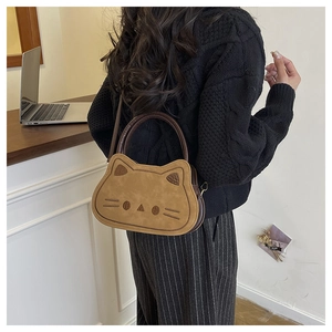 Détail d'un sac bandoulière marron en forme de chat avec texture mate et broderie