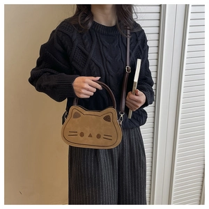 Détail du sac bandoulière marron en forme de chat avec surpiqûres minimalistes du visage