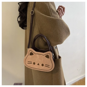 Dettaglio della borsa a tracolla gatto con cinturino regolabile su cappotto beige